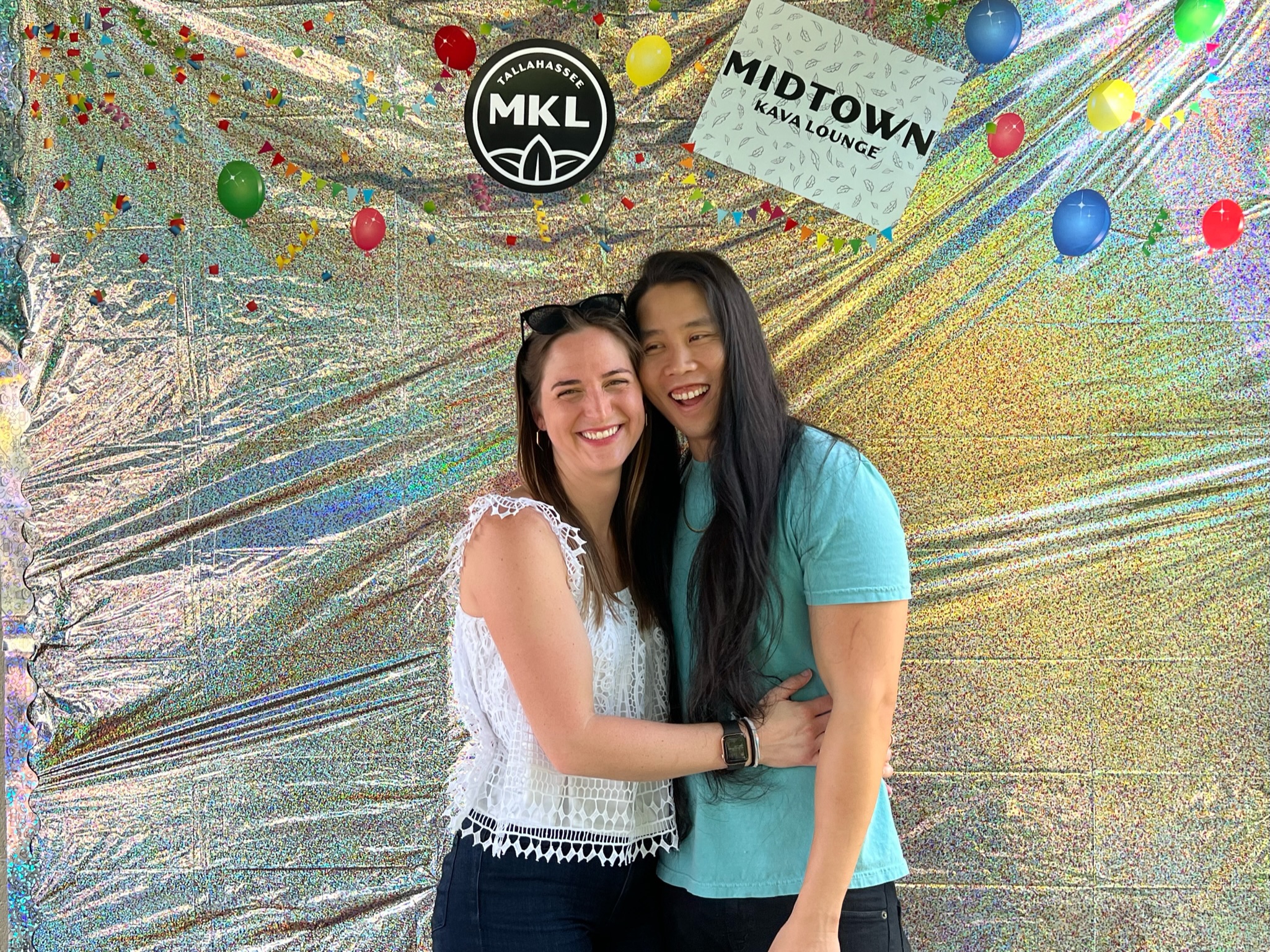 Kevin and Tatum smiling in front of a backdrop for MKL's 5th anniversary