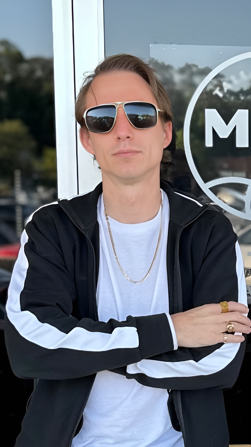 Billy the owner of MKL standing infront of the bar with sunglasses on